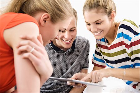 share - Three young adult friends using digital tablet Stock Photo - Premium Royalty-Free, Code: 649-07437851