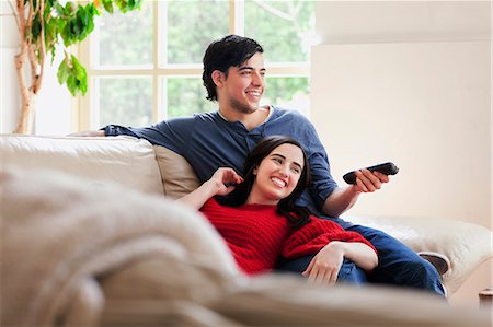 red happy - Young couple watching TV on living room sofa Stock Photo - Premium Royalty-Free, Code: 649-07437889