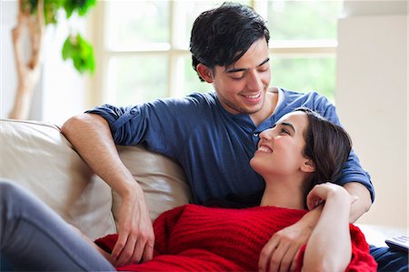 relaxing in home on couch happy couple living room - Young couple reclining on living room sofa Stock Photo - Premium Royalty-Free, Code: 649-07437891