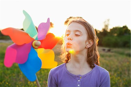 Girl blowing toy windmill Stock Photo - Premium Royalty-Free, Code: 649-07437907