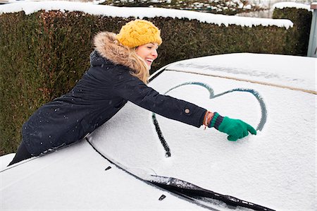 people outside home cold - Woman drawing heart shape on snow covered windscreen Stock Photo - Premium Royalty-Free, Code: 649-07437954