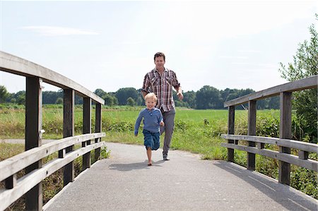 family fun outdoors adventure - Father and son running over wooden bridge Stock Photo - Premium Royalty-Free, Code: 649-07437967