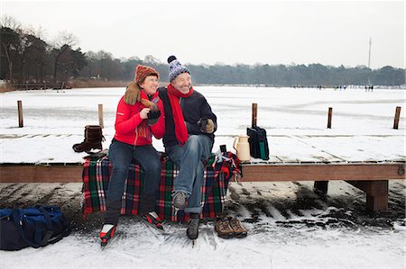 europe woman scarf - Couple sitting on pier having hot drink Foto de stock - Sin royalties Premium, Código: 649-07437997