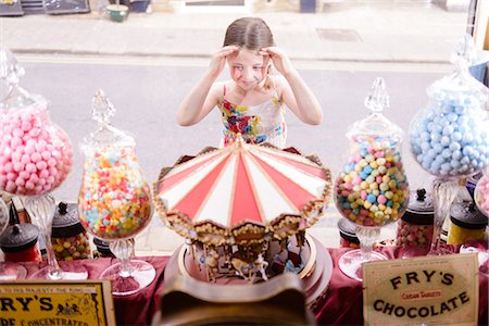 Girl looking through window of sweet shop Foto de stock - Sin royalties Premium, Código: 649-07438037