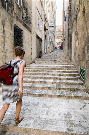 striped woman dress - Female tourist walking up stairs, Valletta, Malta Stock Photo - Premium Royalty-Free, Code: 649-07520126