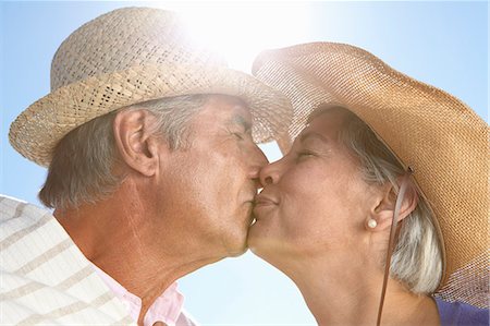 Couple wearing straw hats kissing Stock Photo - Premium Royalty-Free, Code: 649-07520162