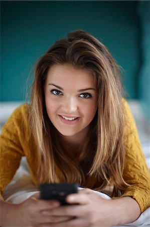 simsearch:649-08901706,k - Portrait of teenage girl in bedroom with smartphone Foto de stock - Royalty Free Premium, Número: 649-07520237