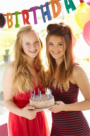 posar (postura) - Two teenage girls holding birthday cake Foto de stock - Sin royalties Premium, Código: 649-07520281