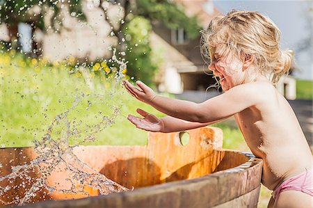 ropa interior - Female toddler splashing hands in water barrel Foto de stock - Sin royalties Premium, Código: 649-07520340