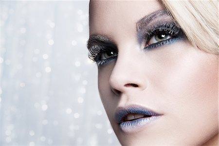 Close up of woman against glittery background Photographie de stock - Premium Libres de Droits, Code: 649-07520416
