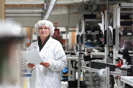 simsearch:649-07520615,k - Female scientist holding paperwork in laser laboratory Foto de stock - Sin royalties Premium, Código: 649-07520615