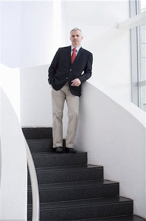 single businessman standing - Portrait of mature businessman on office stairs Stock Photo - Premium Royalty-Free, Code: 649-07520815