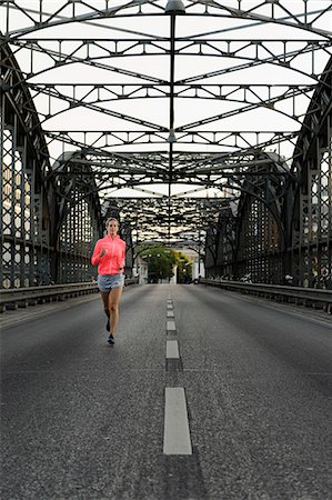 Young female runner across bridge Foto de stock - Sin royalties Premium, Código: 649-07520917