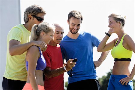 simsearch:649-07520875,k - Mature male trainer and a group of adult runners checking stopwatch Stock Photo - Premium Royalty-Free, Code: 649-07520938