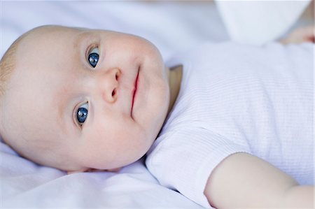 smiling baby portrait - Baby girl lying on bedclothes Photographie de stock - Premium Libres de Droits, Code: 649-07520982