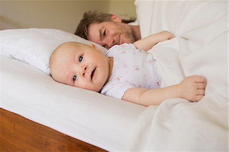 pictures candid bedroom - Father and baby daughter on bed Stock Photo - Premium Royalty-Free, Code: 649-07521019