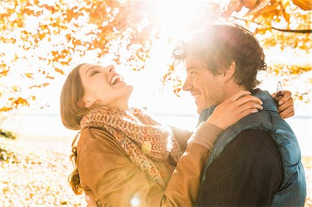 fall season - Couple hugging by tree in sunlight Stock Photo - Premium Royalty-Free, Code: 649-07521112