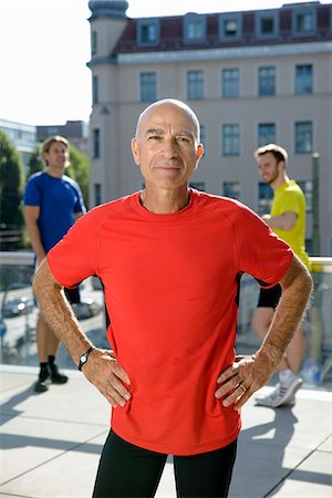 portrait of smiling middle aged man - Mature male trainer and class taking a break on city rooftop Stock Photo - Premium Royalty-Free, Code: 649-07559755