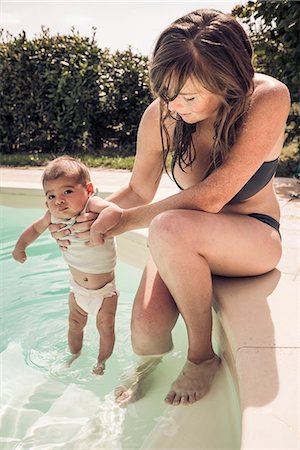 sun care - Mother and baby daughter paddling in swimming pool Foto de stock - Sin royalties Premium, Código: 649-07559772