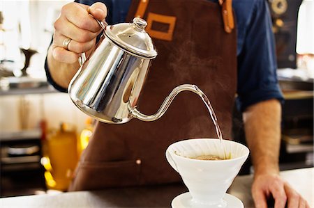 small business preparation - Close up of barista pouring boiling water into coffee filter Stock Photo - Premium Royalty-Free, Code: 649-07559780