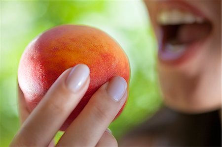 simsearch:649-07559812,k - Woman holding peach to mouth Stock Photo - Premium Royalty-Free, Code: 649-07559809