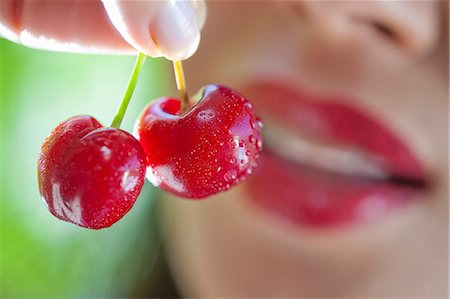 simsearch:649-07559812,k - Woman holding up cherries Stock Photo - Premium Royalty-Free, Code: 649-07559810