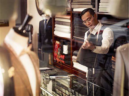 fabrics of asian culture - Tailor looking at fabric in traditional tailors shop Stock Photo - Premium Royalty-Free, Code: 649-07559864