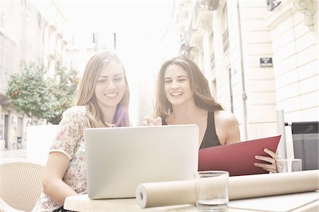 simsearch:649-07560110,k - Two young female friends looking at laptop at sidewalk cafe, Valencia, Spain Stock Photo - Premium Royalty-Free, Code: 649-07560109