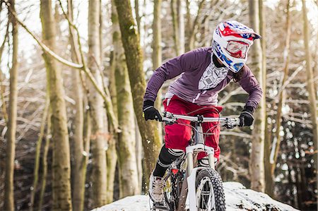 snow sports - Young female mountain biker riding through forest Stock Photo - Premium Royalty-Free, Code: 649-07560119