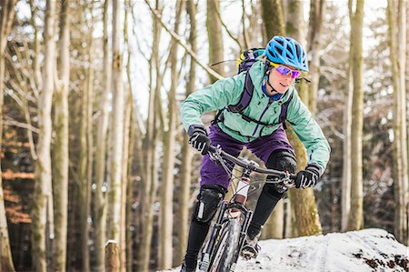 simsearch:649-07560070,k - Female mountain biker riding through forest Photographie de stock - Premium Libres de Droits, Code: 649-07560120