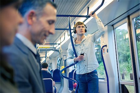 pendeln (pendelverkehr) - Young man on train listening to headphones Foto de stock - Sin royalties Premium, Código: 649-07560164