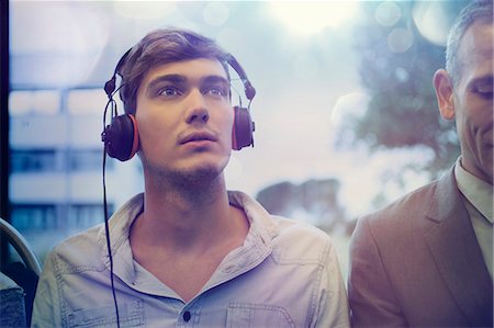Young man daydreaming and listening to headphones on train Stock Photo - Premium Royalty-Free, Code: 649-07560168