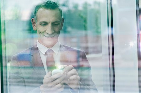 reflection, window - Businessman with glowing finger using smartphone touchscreen Stock Photo - Premium Royalty-Free, Code: 649-07560169