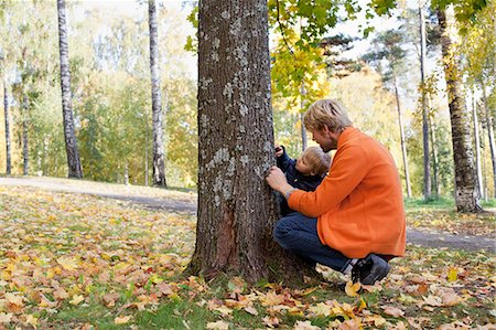 Father and son playing at bottom of tree Photographie de stock - Premium Libres de Droits, Code: 649-07560336