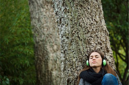 Young woman listening to music in forest Stock Photo - Premium Royalty-Free, Code: 649-07560416