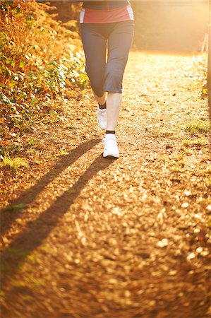 running feet - Mature woman jogging on path in sunlight, low section Stock Photo - Premium Royalty-Free, Code: 649-07560456