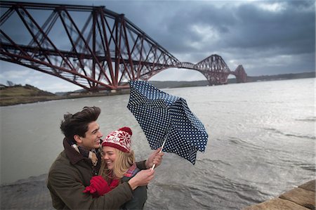 A young couple pose in front of the Forth Rail Bridge in Queensferry, near Edinburgh, Scotland Photographie de stock - Premium Libres de Droits, Code: 649-07560518