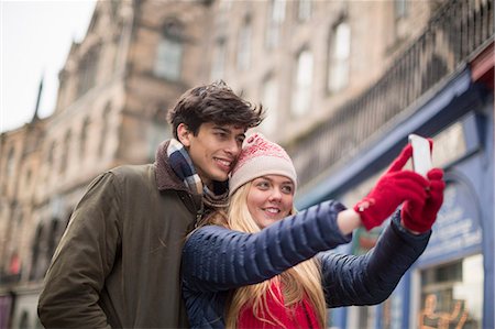 simsearch:649-07560509,k - A young couple photograph themselves in the Grassmarket in Edinburgh, Scotland Fotografie stock - Premium Royalty-Free, Codice: 649-07560530