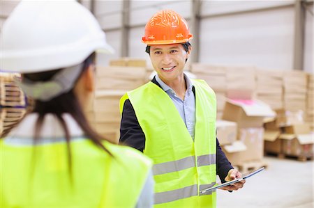 Supervisor shaking hands with trainee in distribution warehouse Stock Photo - Premium Royalty-Free, Code: 649-07585262