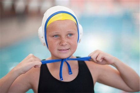 swimming pool and children and swim cap - Portrait of schoolgirl water polo player fastening swimming cap Stock Photo - Premium Royalty-Free, Code: 649-07585407