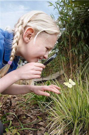 Close up of schoolgirl looking at butterfly in garden Photographie de stock - Premium Libres de Droits, Code: 649-07585422