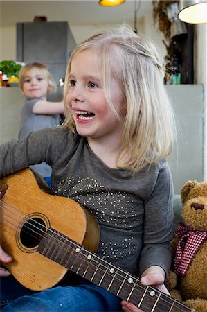 elementary age - Young girl playing acoustic guitar Stock Photo - Premium Royalty-Free, Code: 649-07585431