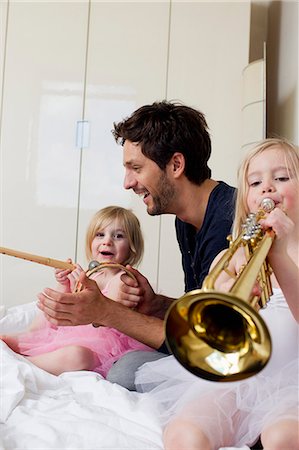 Father and two young daughters playing music Stock Photo - Premium Royalty-Free, Code: 649-07585447