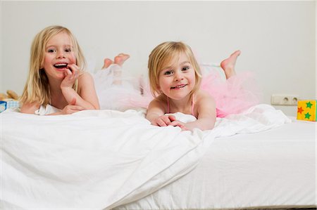 Portrait of two young sisters lying on bed Photographie de stock - Premium Libres de Droits, Code: 649-07585453