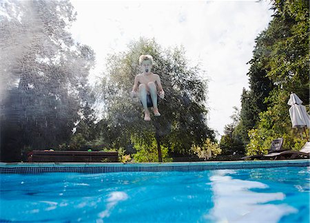 explosif - Boy jumping into swimming pool Photographie de stock - Premium Libres de Droits, Code: 649-07585494
