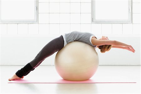 fit woman - Young woman stretching on exercise ball Stock Photo - Premium Royalty-Free, Code: 649-07585529