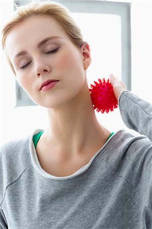 Young woman using massage ball on neck Stock Photo - Premium Royalty-Free, Code: 649-07585534