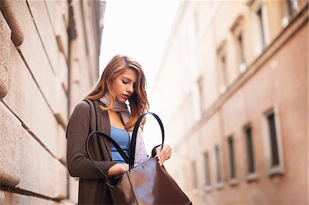 Young woman anxiously searching her shoulder bag Stock Photo - Premium Royalty-Free, Code: 649-07585560