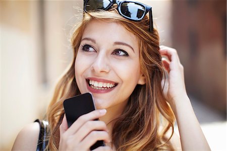 Sophisticated young woman with smartphone looking up Photographie de stock - Premium Libres de Droits, Code: 649-07585573