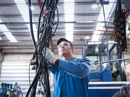 Engineer installing new electrics in truck repair factory Photographie de stock - Premium Libres de Droits, Code: 649-07585607